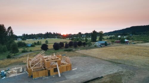 A small modern wooden cottage against an open landscape