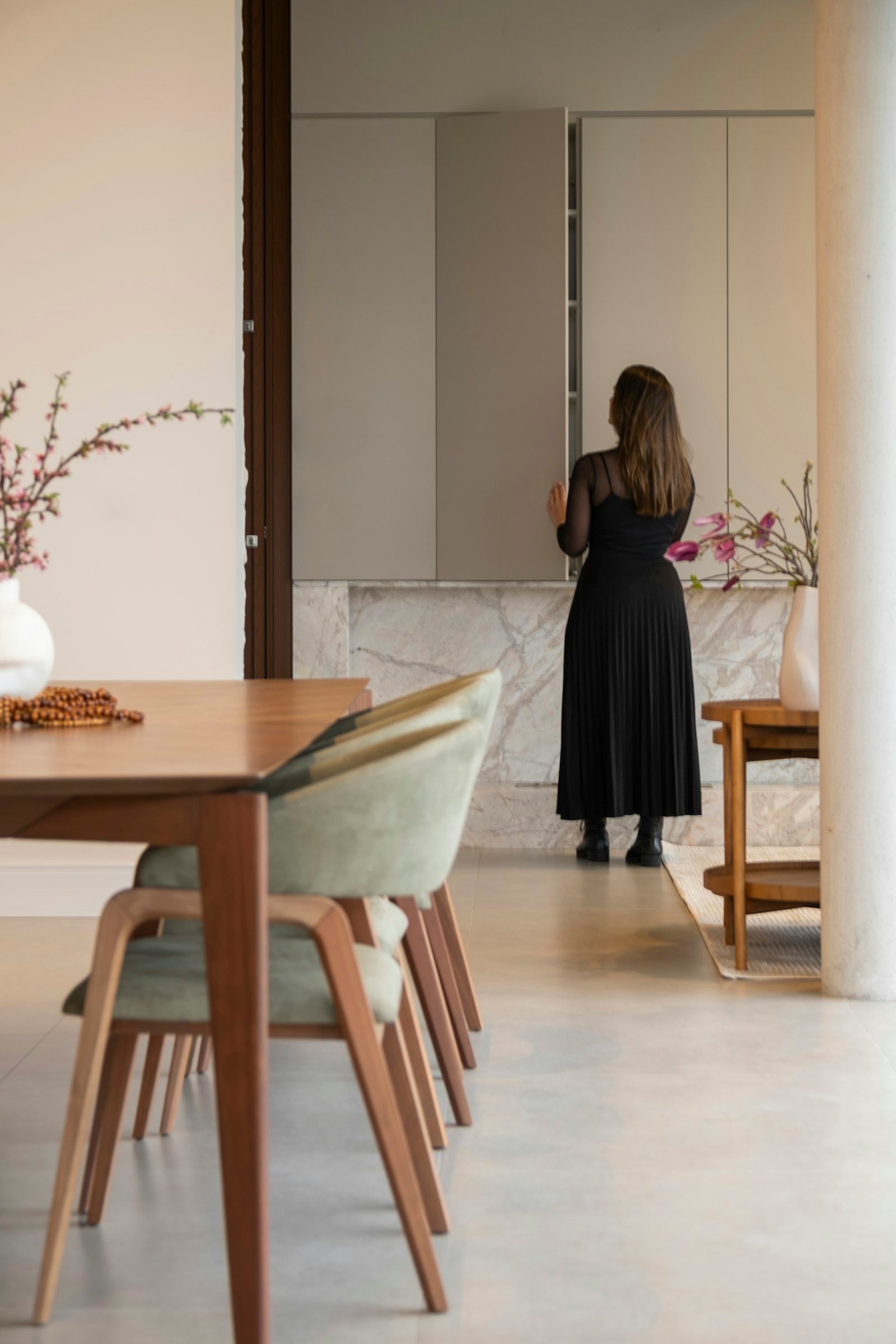 Black woman in a black dress standing in a modern kitchen