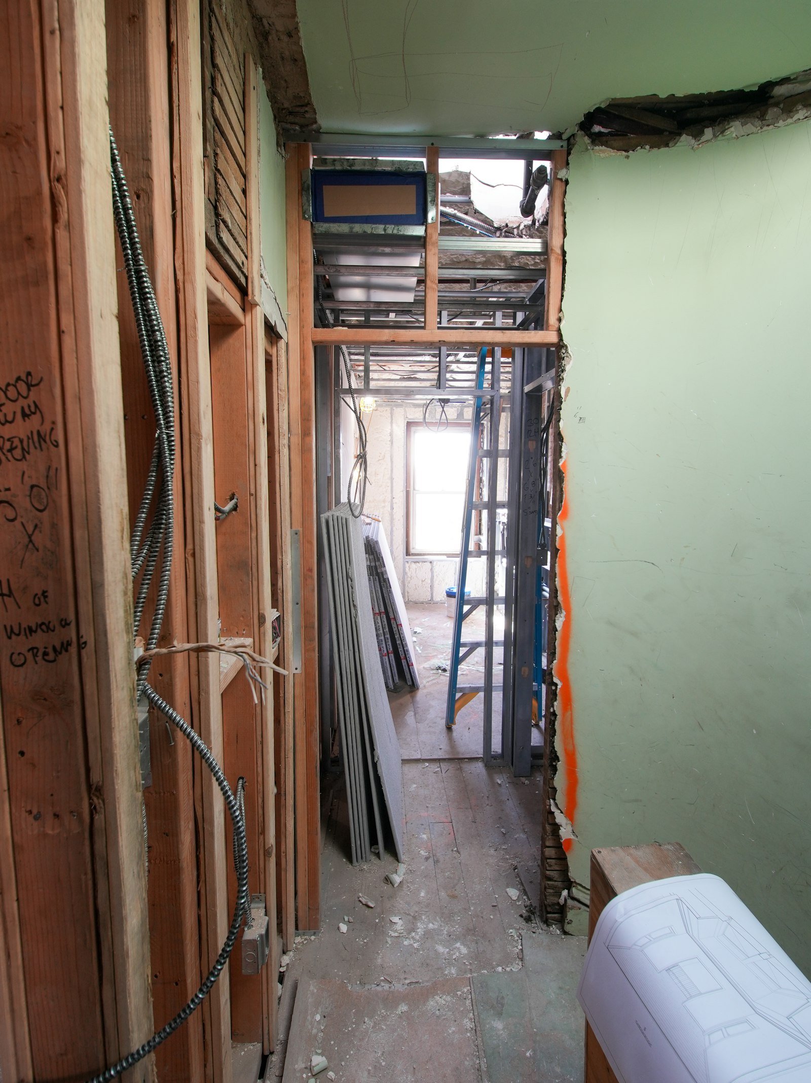 Hallway of a home mid-construction with exposed wood framing